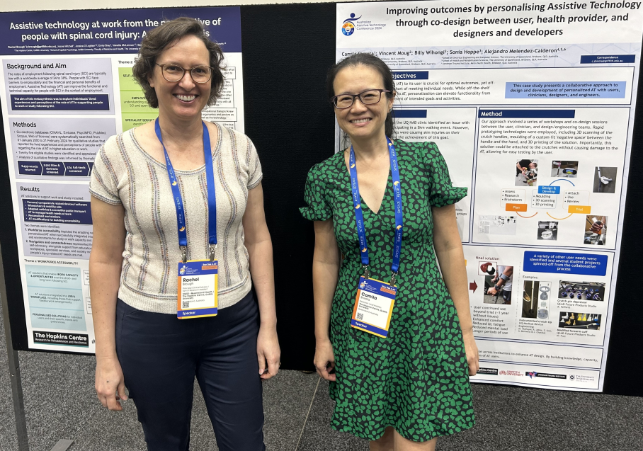 Two Hopkins Researchers, Rachel Brough and Camila Shirota, stand in front of their poster presentations. 