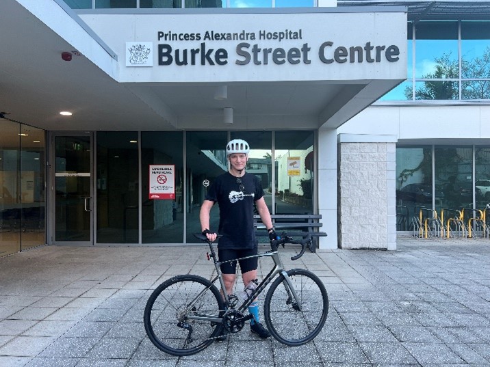 Dr Nick Aitcheson Standing in front of the Burke Street Pain Clinic, with his bike. 